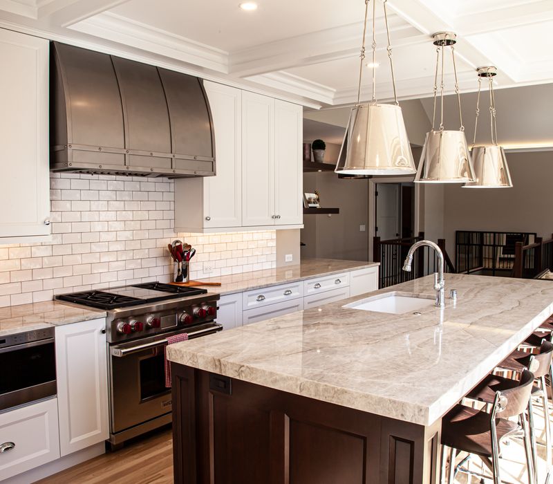 This lakeside brick home has vaulted and coffered ceilings, twin picture windows on either side of a fireplace, hardwood floors, two second-story decks, and a finished basement. 