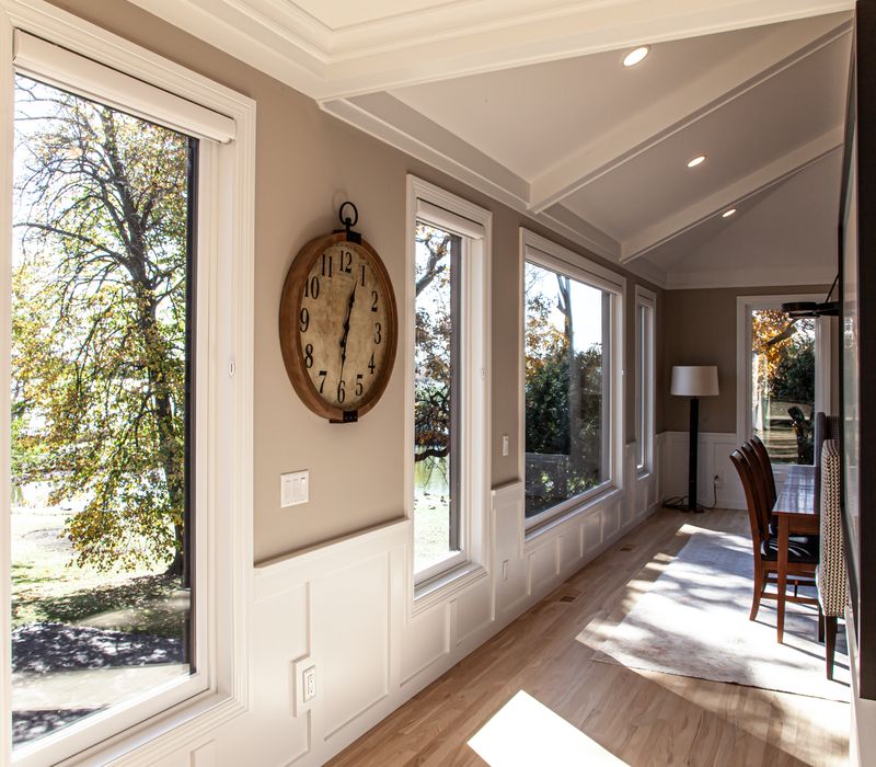 This lakeside brick home has vaulted and coffered ceilings, twin picture windows on either side of a fireplace, hardwood floors, two second-story decks, and a finished basement. 