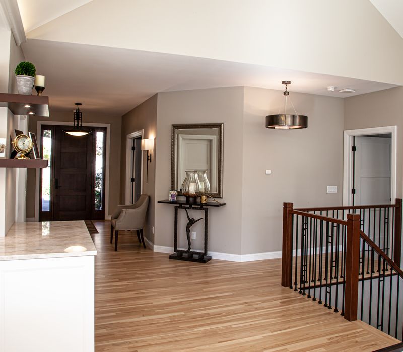 This lakeside brick home has vaulted and coffered ceilings, twin picture windows on either side of a fireplace, hardwood floors, two second-story decks, and a finished basement. 