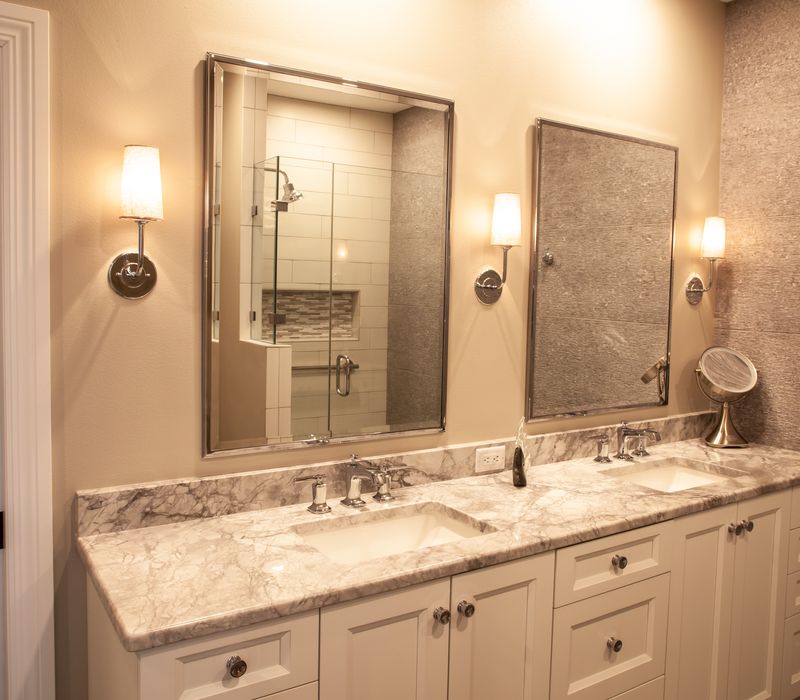 This lakeside brick home has vaulted and coffered ceilings, twin picture windows on either side of a fireplace, hardwood floors, two second-story decks, and a finished basement. 