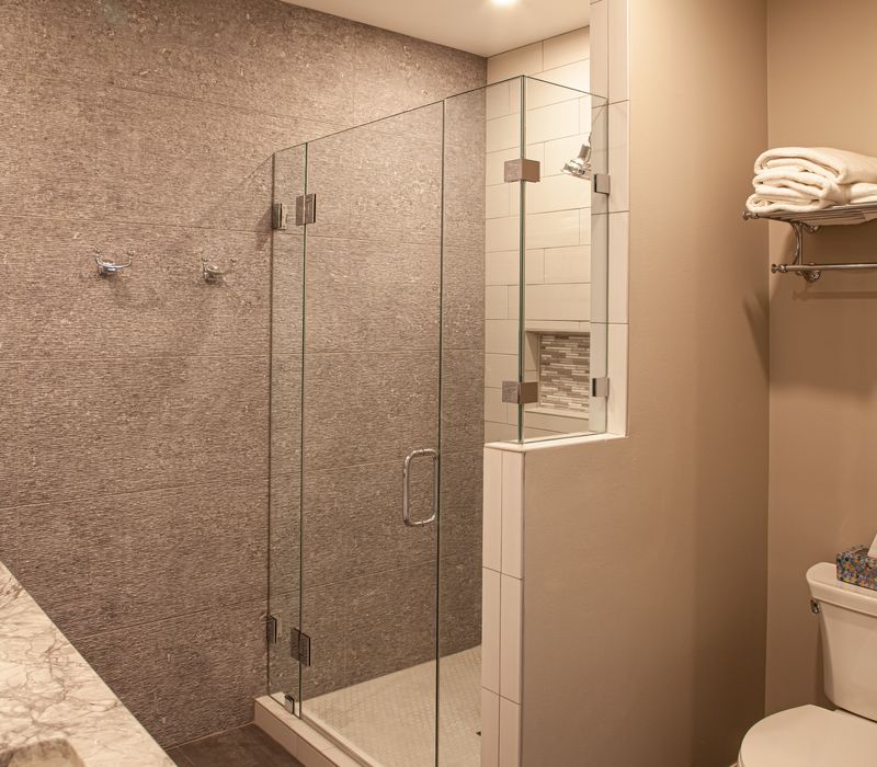 This lakeside brick home has vaulted and coffered ceilings, twin picture windows on either side of a fireplace, hardwood floors, two second-story decks, and a finished basement. 