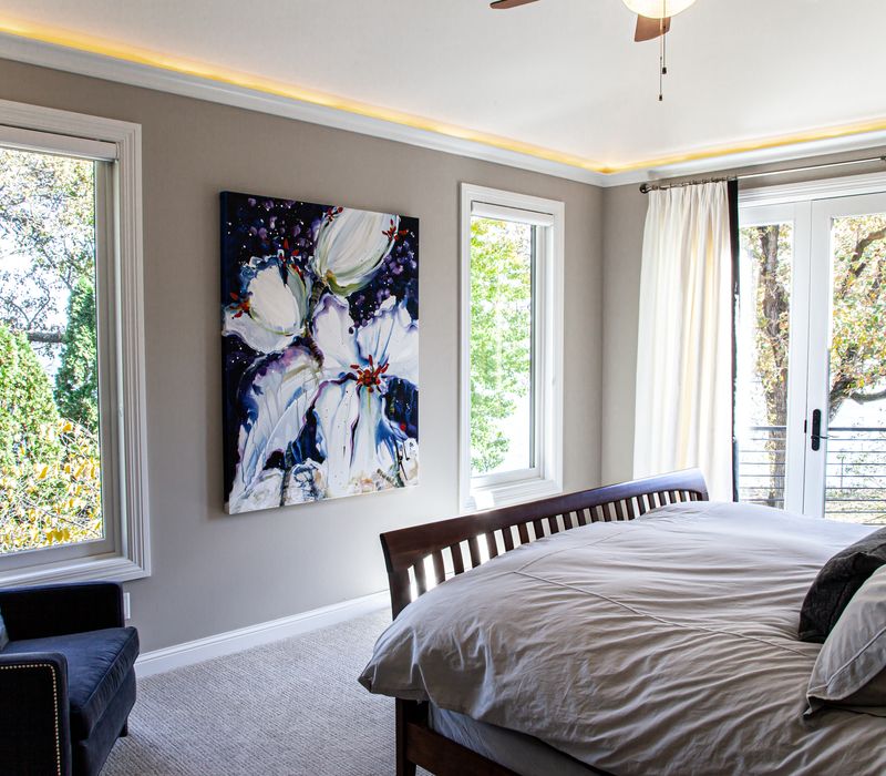 This lakeside brick home has vaulted and coffered ceilings, twin picture windows on either side of a fireplace, hardwood floors, two second-story decks, and a finished basement. 