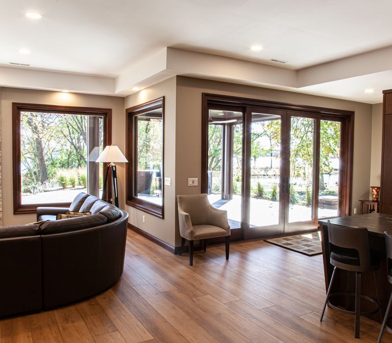 This lakeside brick home has vaulted and coffered ceilings, twin picture windows on either side of a fireplace, hardwood floors, two second-story decks, and a finished basement. 