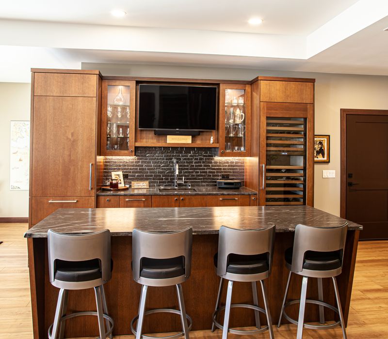 This lakeside brick home has vaulted and coffered ceilings, twin picture windows on either side of a fireplace, hardwood floors, two second-story decks, and a finished basement. 