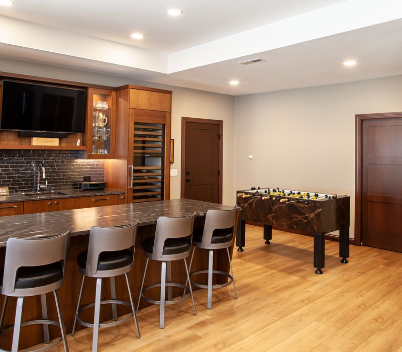 This lakeside brick home has vaulted and coffered ceilings, twin picture windows on either side of a fireplace, hardwood floors, two second-story decks, and a finished basement. 