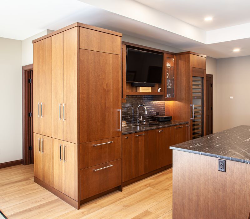 This lakeside brick home has vaulted and coffered ceilings, twin picture windows on either side of a fireplace, hardwood floors, two second-story decks, and a finished basement. 