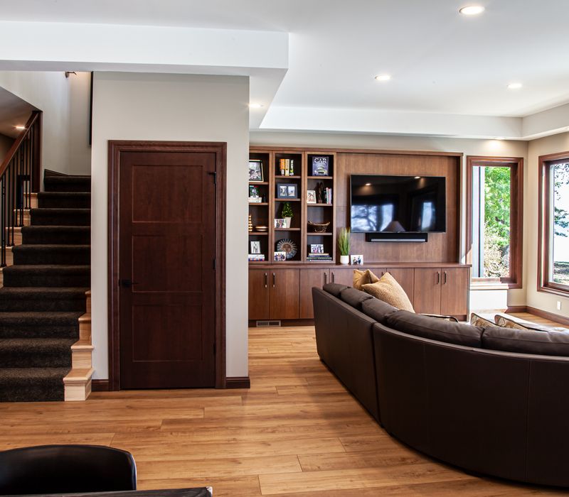 This lakeside brick home has vaulted and coffered ceilings, twin picture windows on either side of a fireplace, hardwood floors, two second-story decks, and a finished basement. 