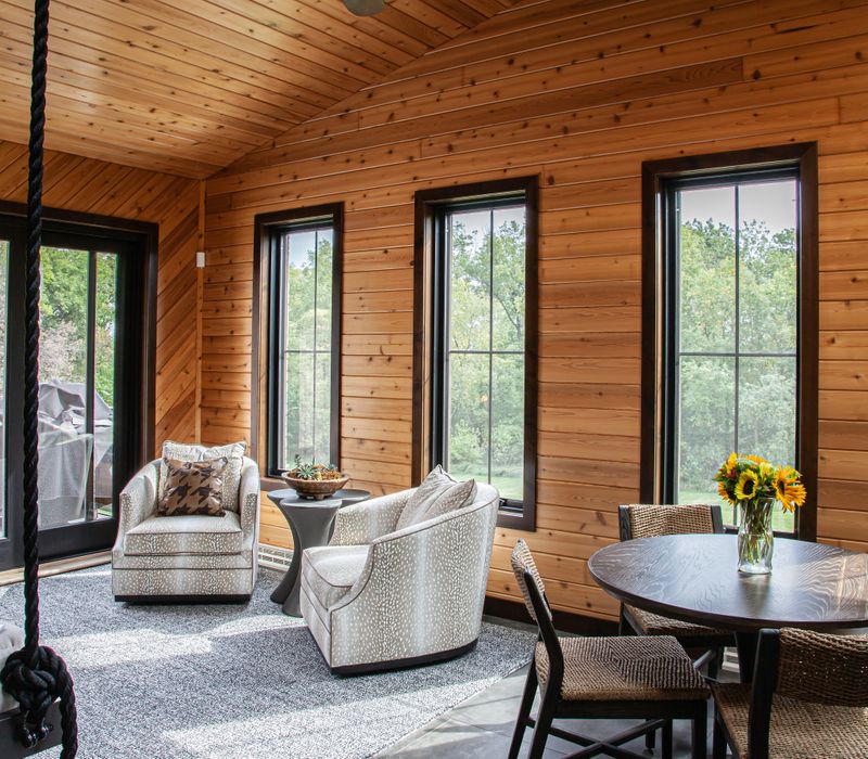 This house includes a brushed steel range hood, a live edge countertop, stone-seeded glass pendant lamps, skylights, and a barn door pantry. 