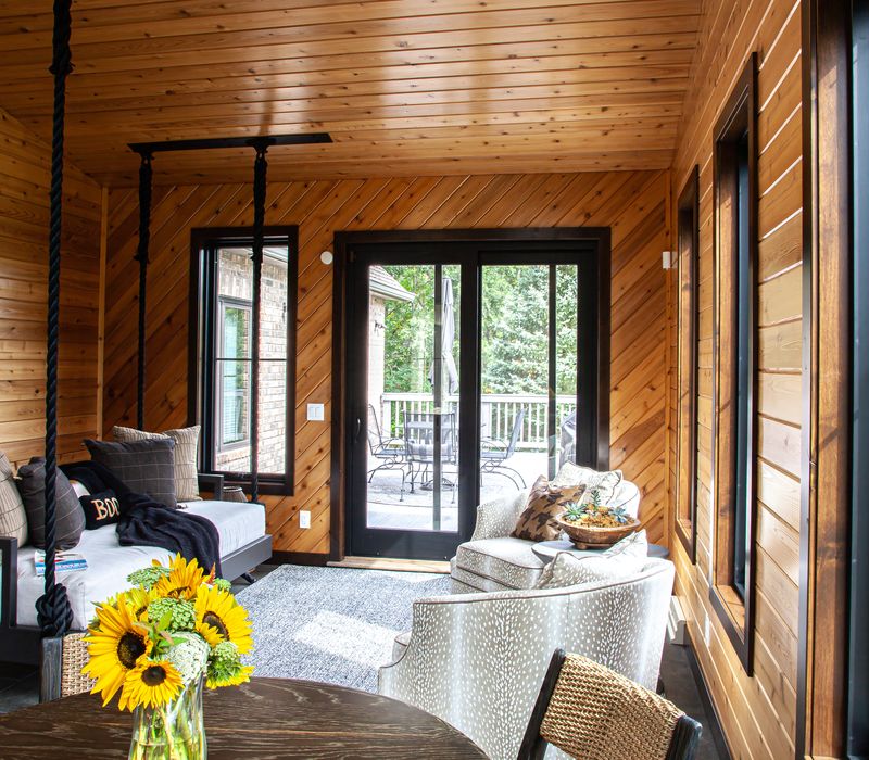 This house includes a brushed steel range hood, a live edge countertop, stone-seeded glass pendant lamps, skylights, and a barn door pantry. 