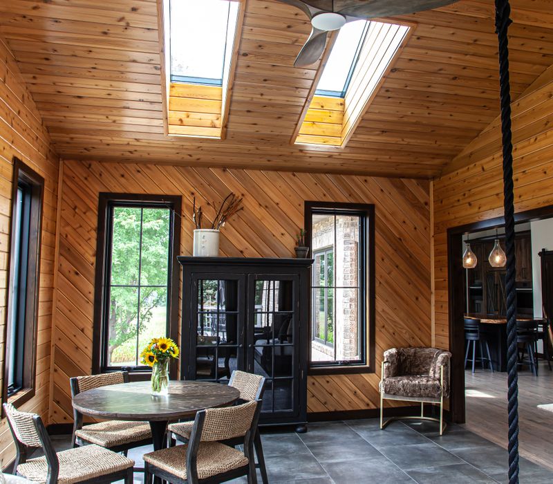 This house includes a brushed steel range hood, a live edge countertop, stone-seeded glass pendant lamps, skylights, and a barn door pantry. 