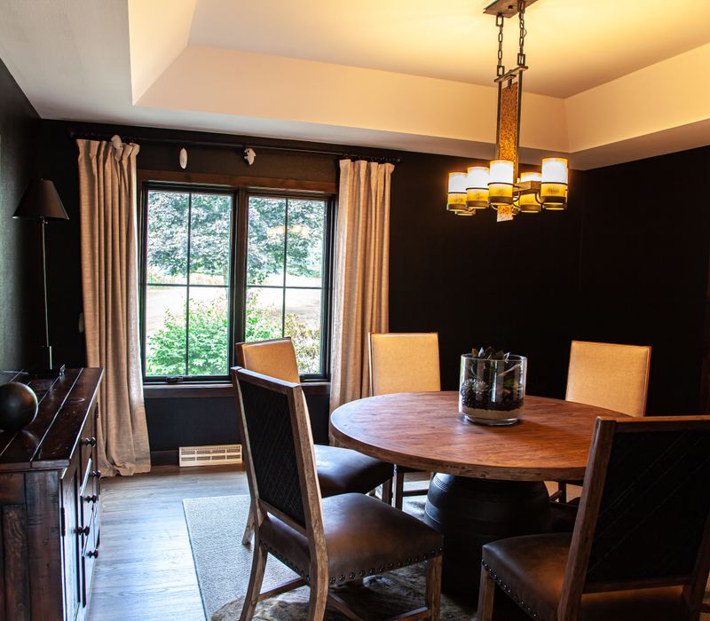 This house includes a brushed steel range hood, a live edge countertop, stone-seeded glass pendant lamps, skylights, and a barn door pantry. 