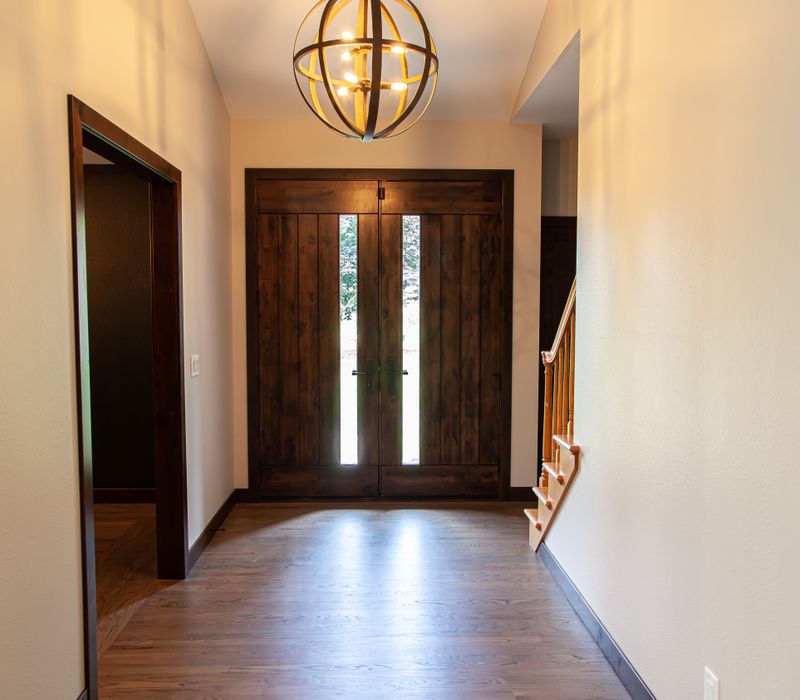 This house includes a brushed steel range hood, a live edge countertop, stone-seeded glass pendant lamps, skylights, and a barn door pantry. 