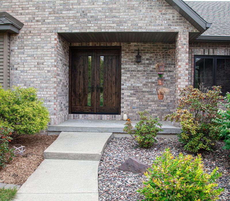 This house includes a brushed steel range hood, a live edge countertop, stone-seeded glass pendant lamps, skylights, and a barn door pantry. 