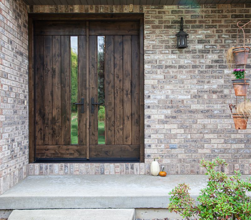 This house includes a brushed steel range hood, a live edge countertop, stone-seeded glass pendant lamps, skylights, and a barn door pantry. 