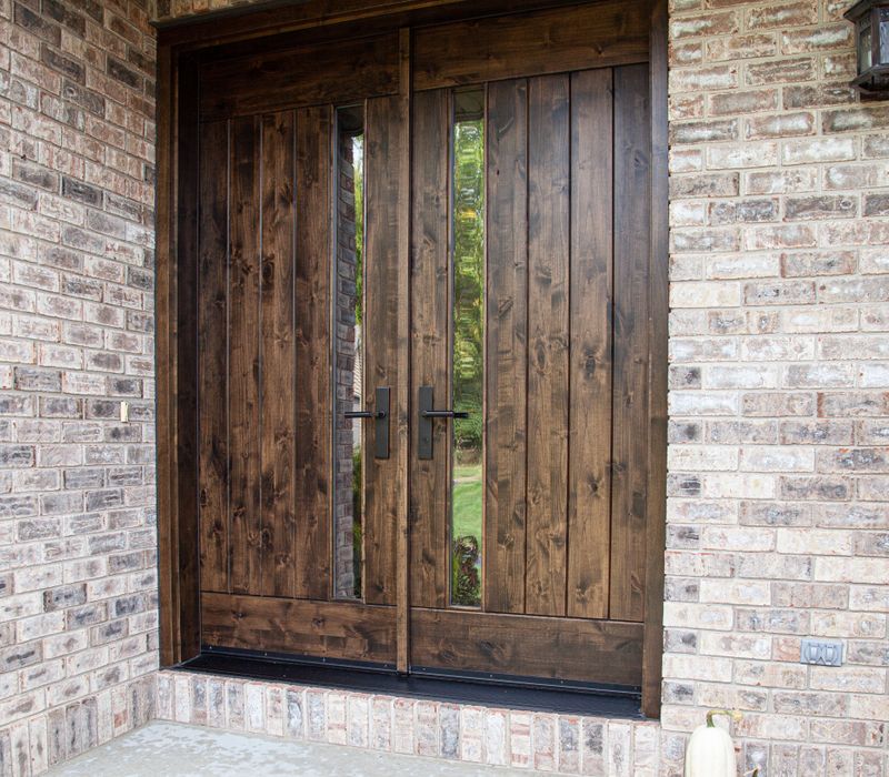 This house includes a brushed steel range hood, a live edge countertop, stone-seeded glass pendant lamps, skylights, and a barn door pantry. 