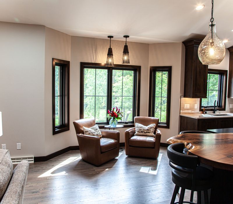 This house includes a brushed steel range hood, a live edge countertop, stone-seeded glass pendant lamps, skylights, and a barn door pantry. 