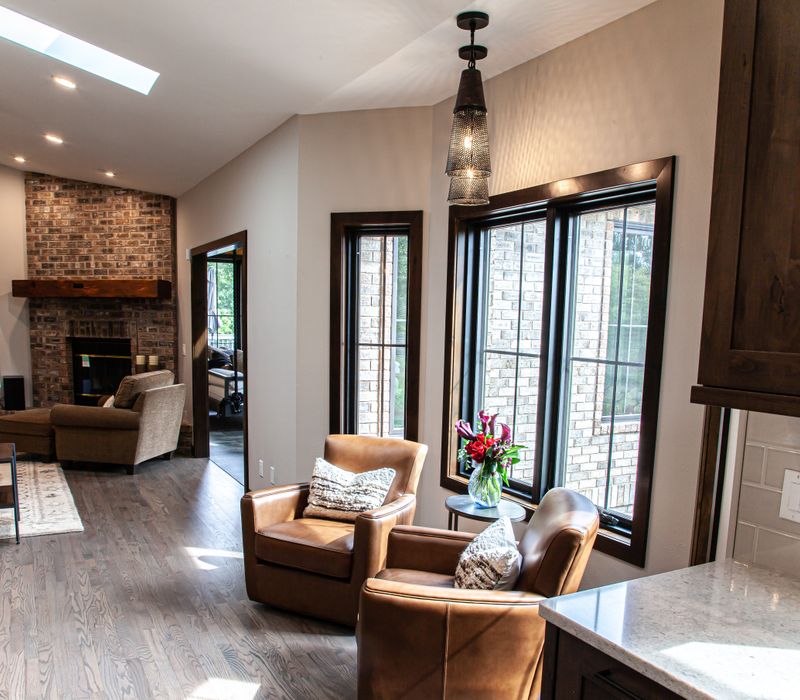 This house includes a brushed steel range hood, a live edge countertop, stone-seeded glass pendant lamps, skylights, and a barn door pantry. 