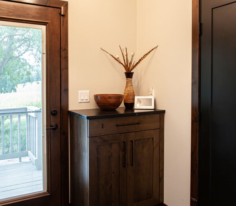 This house includes a brushed steel range hood, a live edge countertop, stone-seeded glass pendant lamps, skylights, and a barn door pantry. 