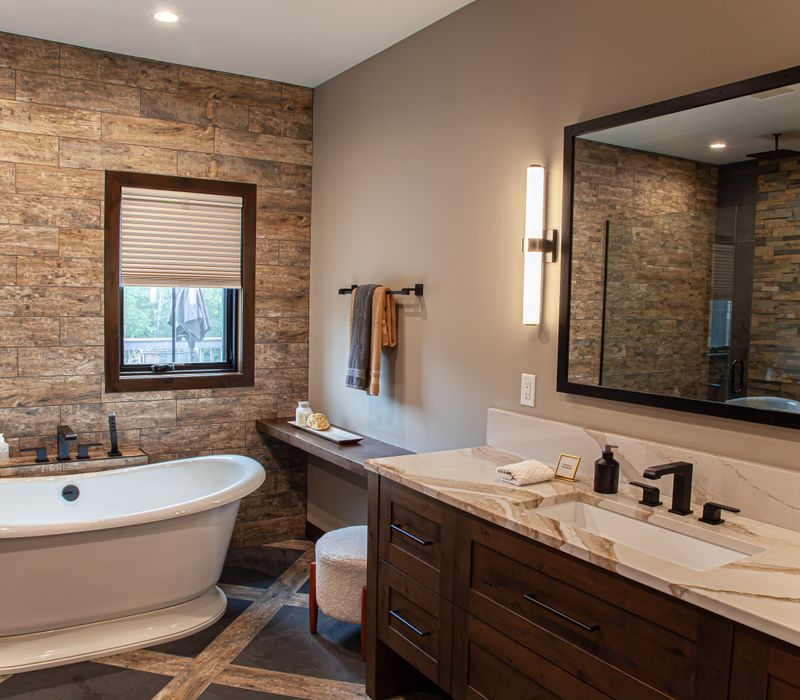 This house includes a brushed steel range hood, a live edge countertop, stone-seeded glass pendant lamps, skylights, and a barn door pantry. 