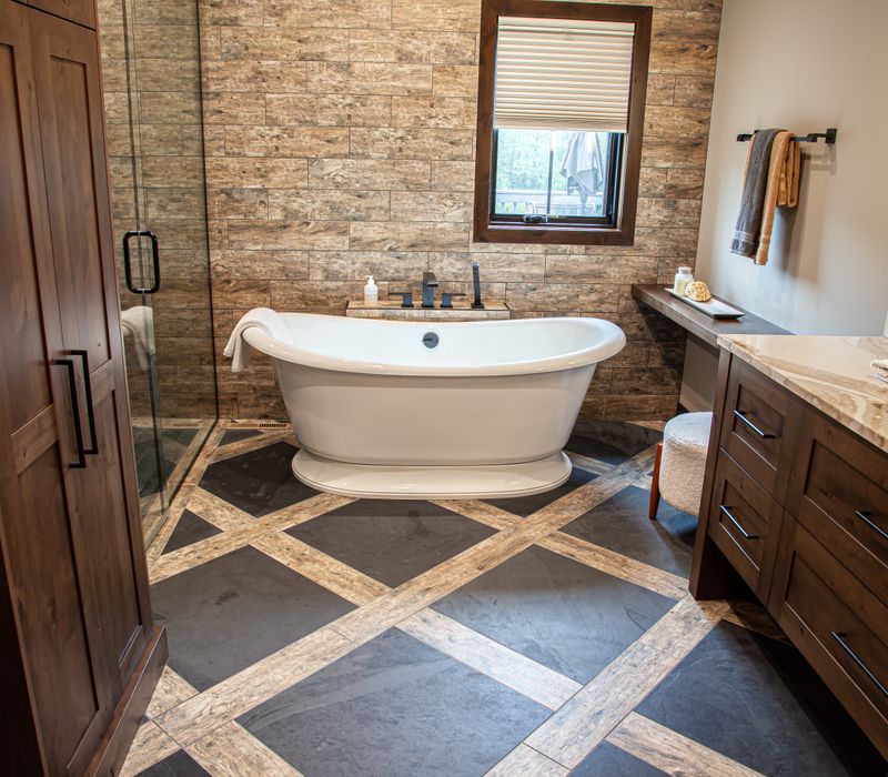 This house includes a brushed steel range hood, a live edge countertop, stone-seeded glass pendant lamps, skylights, and a barn door pantry. 