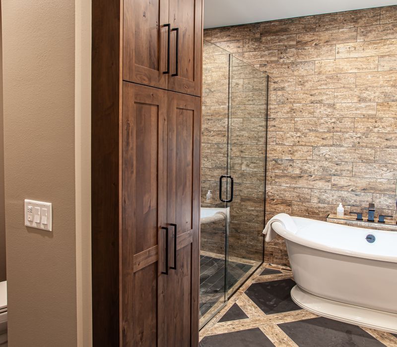 This house includes a brushed steel range hood, a live edge countertop, stone-seeded glass pendant lamps, skylights, and a barn door pantry. 