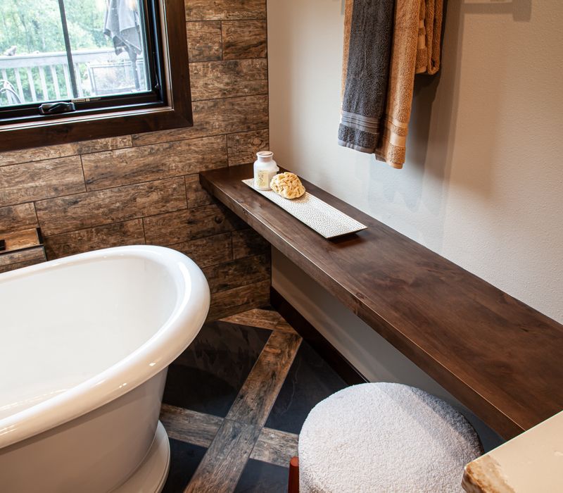 This house includes a brushed steel range hood, a live edge countertop, stone-seeded glass pendant lamps, skylights, and a barn door pantry. 