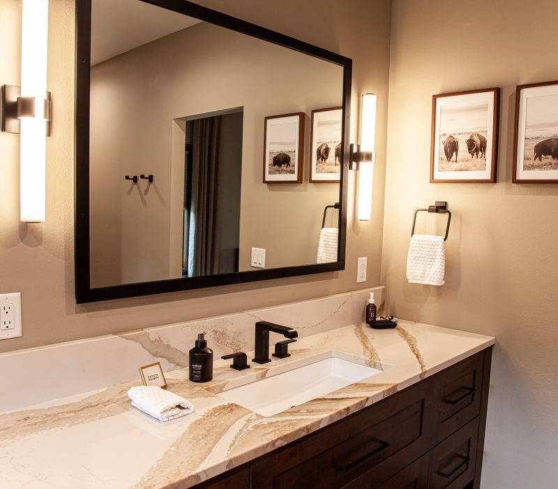 This house includes a brushed steel range hood, a live edge countertop, stone-seeded glass pendant lamps, skylights, and a barn door pantry. 