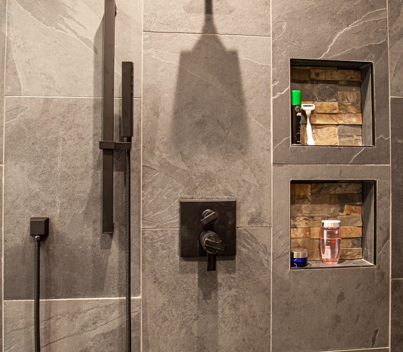 This house includes a brushed steel range hood, a live edge countertop, stone-seeded glass pendant lamps, skylights, and a barn door pantry. 