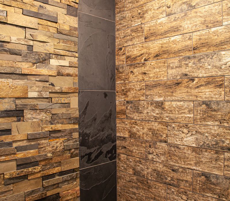 This house includes a brushed steel range hood, a live edge countertop, stone-seeded glass pendant lamps, skylights, and a barn door pantry. 