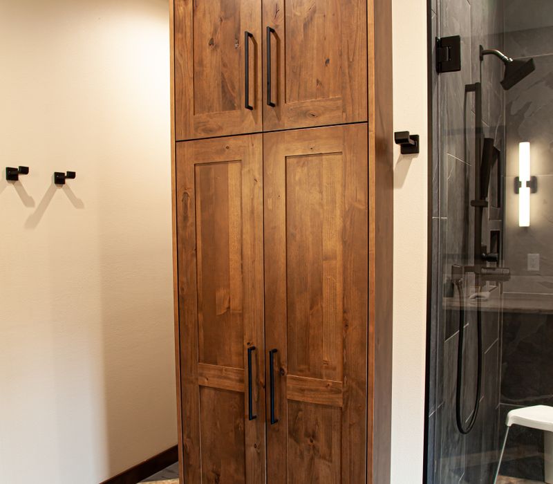 This house includes a brushed steel range hood, a live edge countertop, stone-seeded glass pendant lamps, skylights, and a barn door pantry. 