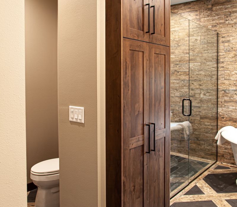 This house includes a brushed steel range hood, a live edge countertop, stone-seeded glass pendant lamps, skylights, and a barn door pantry. 