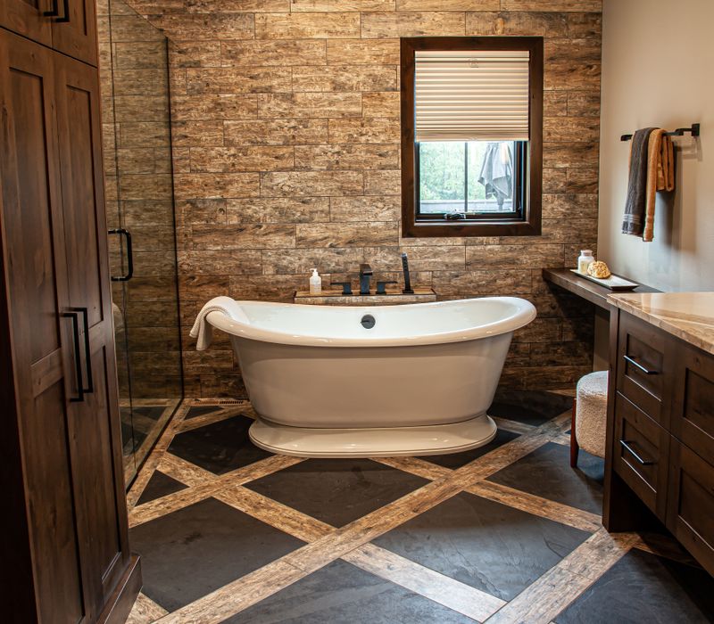 This house includes a brushed steel range hood, a live edge countertop, stone-seeded glass pendant lamps, skylights, and a barn door pantry. 