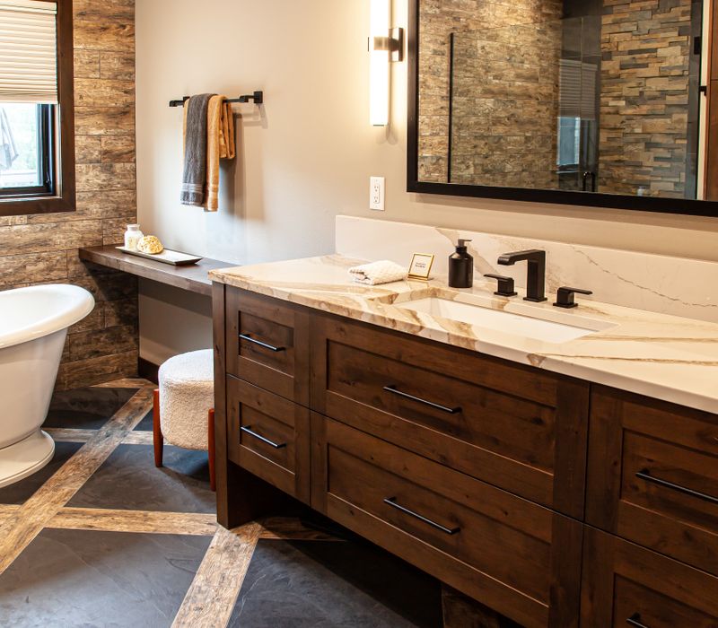 This house includes a brushed steel range hood, a live edge countertop, stone-seeded glass pendant lamps, skylights, and a barn door pantry. 
