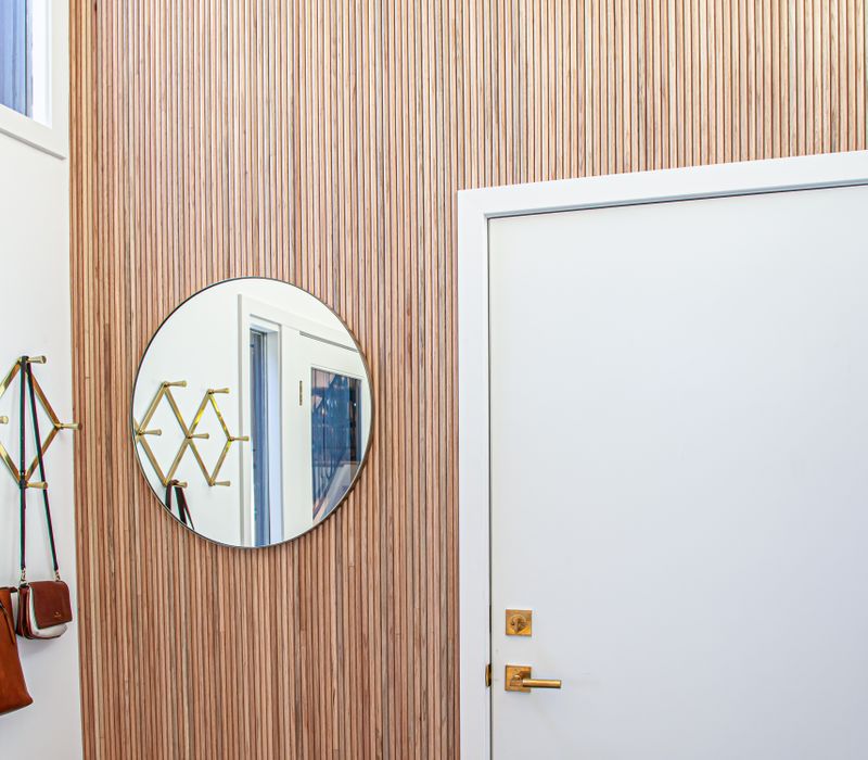 This remodeled split-level home features retro touches in an open contemporary space, and includes a craft room, central brick fireplace, exposed wood ceiling beams, and an open riser staircase. 