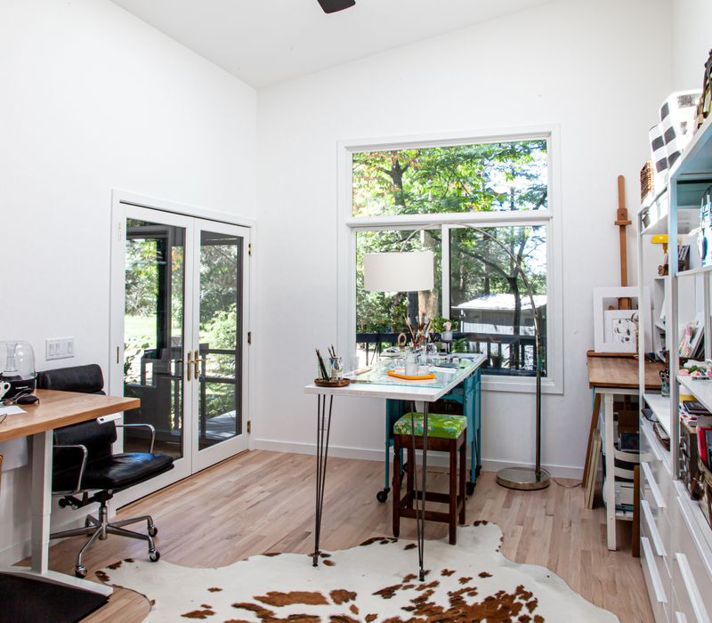 This remodeled split-level home features retro touches in an open contemporary space, and includes a craft room, central brick fireplace, exposed wood ceiling beams, and an open riser staircase. 