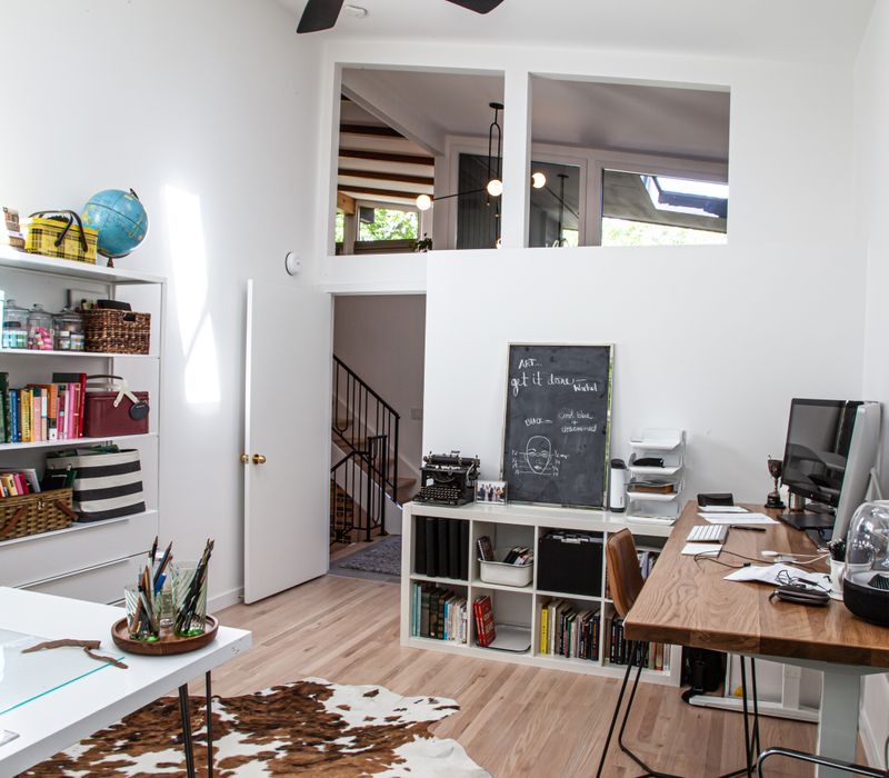 This remodeled split-level home features retro touches in an open contemporary space, and includes a craft room, central brick fireplace, exposed wood ceiling beams, and an open riser staircase. 