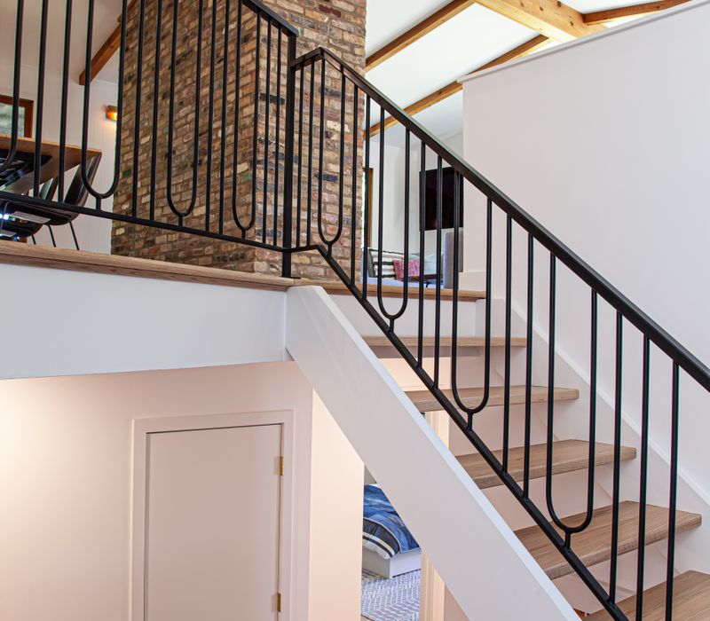 This remodeled split-level home features retro touches in an open contemporary space, and includes a craft room, central brick fireplace, exposed wood ceiling beams, and an open riser staircase. 