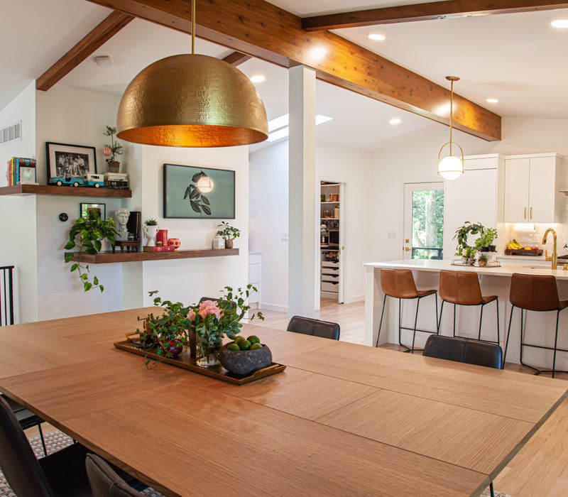 This remodeled split-level home features retro touches in an open contemporary space, and includes a craft room, central brick fireplace, exposed wood ceiling beams, and an open riser staircase. 