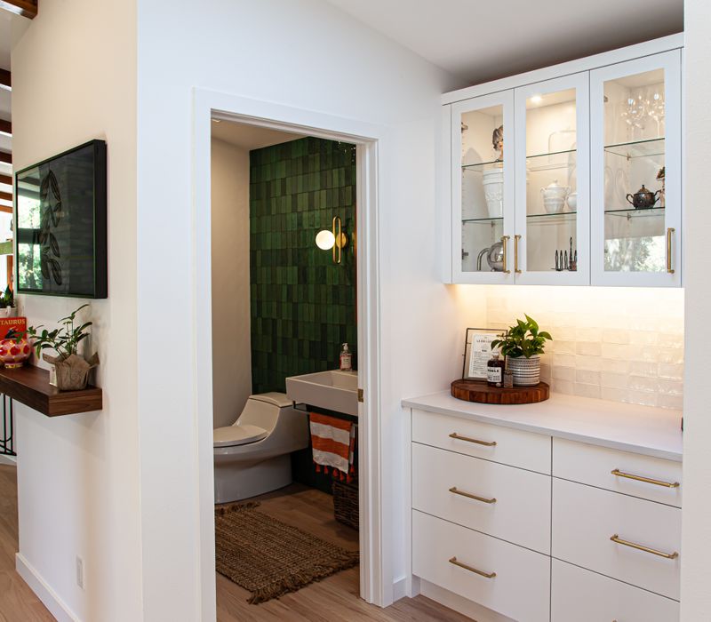 This remodeled split-level home features retro touches in an open contemporary space, and includes a craft room, central brick fireplace, exposed wood ceiling beams, and an open riser staircase. 