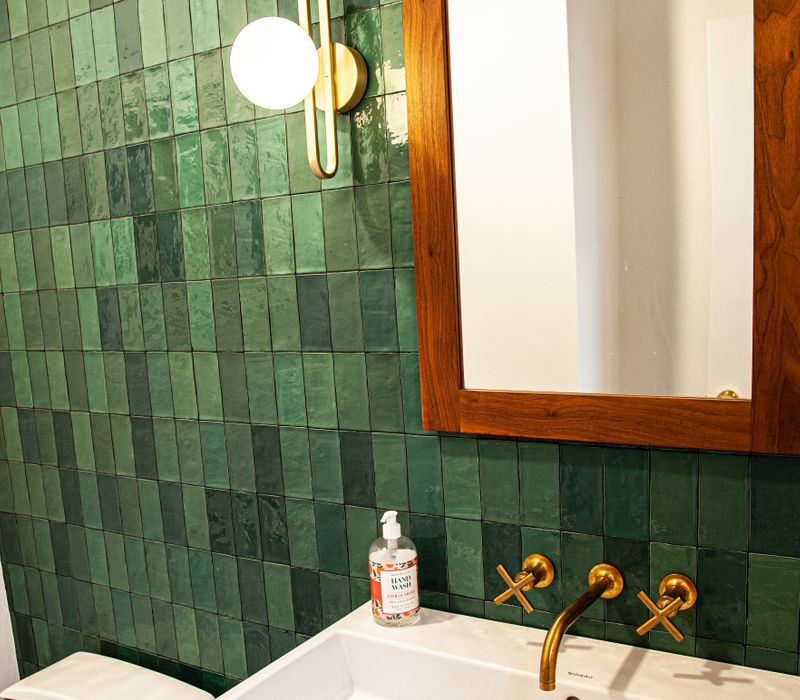 This remodeled split-level home features retro touches in an open contemporary space, and includes a craft room, central brick fireplace, exposed wood ceiling beams, and an open riser staircase. 