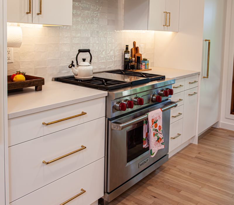 This remodeled split-level home features retro touches in an open contemporary space, and includes a craft room, central brick fireplace, exposed wood ceiling beams, and an open riser staircase. 