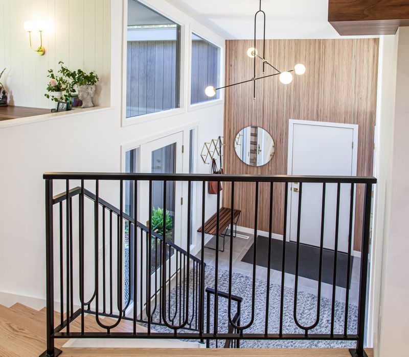 This remodeled split-level home features retro touches in an open contemporary space, and includes a craft room, central brick fireplace, exposed wood ceiling beams, and an open riser staircase. 