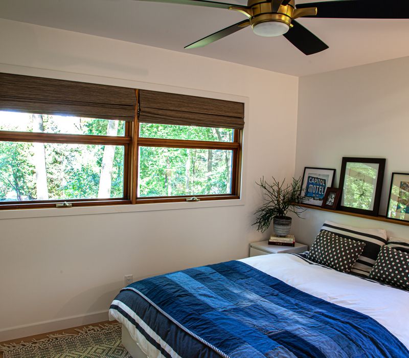 This remodeled split-level home features retro touches in an open contemporary space, and includes a craft room, central brick fireplace, exposed wood ceiling beams, and an open riser staircase. 