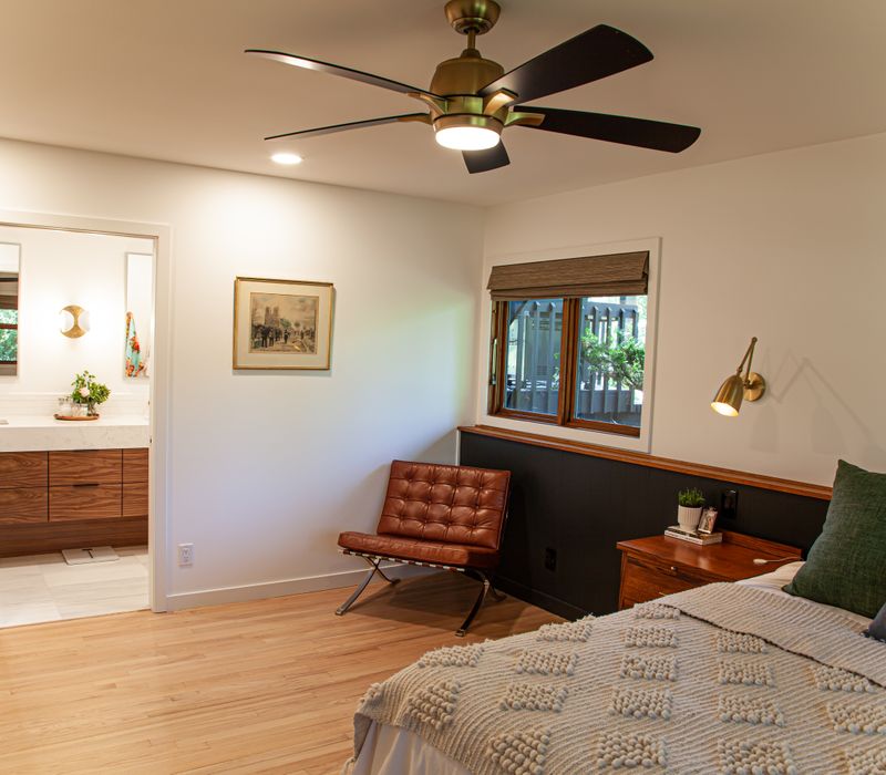 This remodeled split-level home features retro touches in an open contemporary space, and includes a craft room, central brick fireplace, exposed wood ceiling beams, and an open riser staircase. 