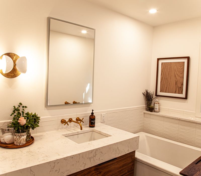 This remodeled split-level home features retro touches in an open contemporary space, and includes a craft room, central brick fireplace, exposed wood ceiling beams, and an open riser staircase. 