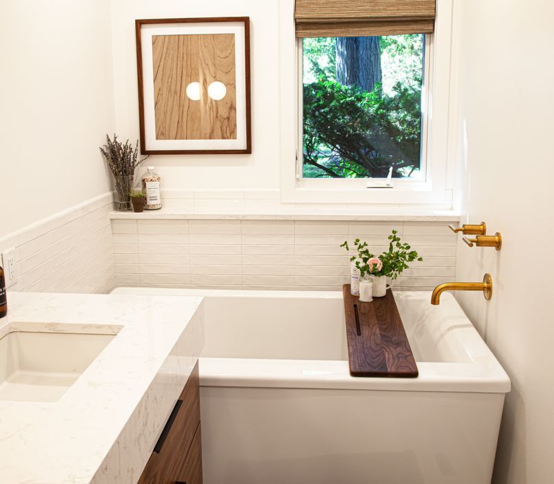 This remodeled split-level home features retro touches in an open contemporary space, and includes a craft room, central brick fireplace, exposed wood ceiling beams, and an open riser staircase. 