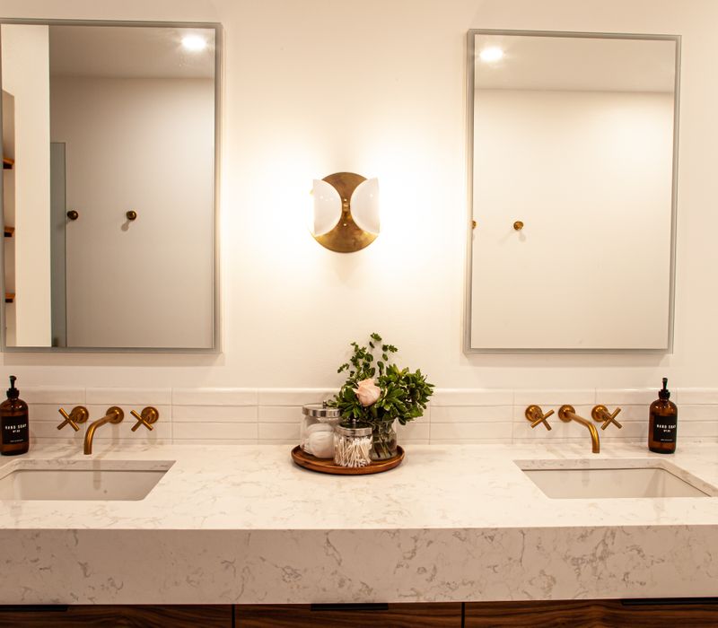 This remodeled split-level home features retro touches in an open contemporary space, and includes a craft room, central brick fireplace, exposed wood ceiling beams, and an open riser staircase. 