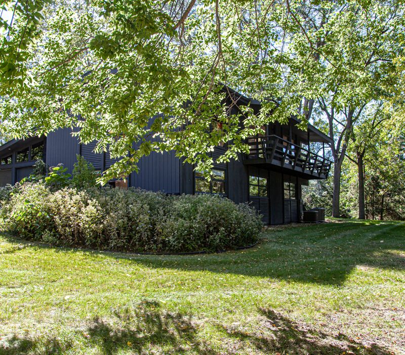 This remodeled split-level home features retro touches in an open contemporary space, and includes a craft room, central brick fireplace, exposed wood ceiling beams, and an open riser staircase. 