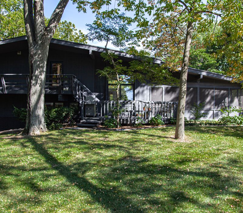 This remodeled split-level home features retro touches in an open contemporary space, and includes a craft room, central brick fireplace, exposed wood ceiling beams, and an open riser staircase. 