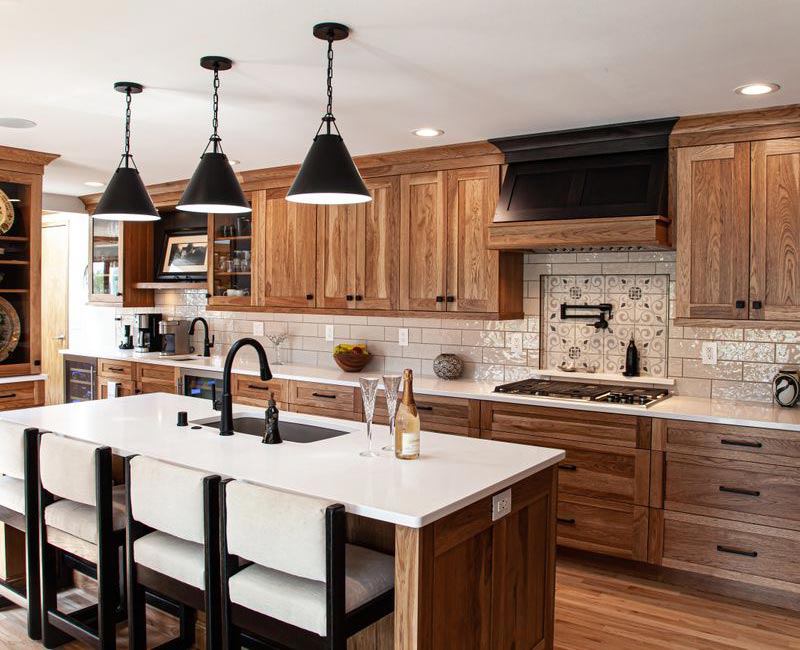 Contemporary black and white geometric accents play off the warm traditional wood cabinetry of this sophisticated kitchen.